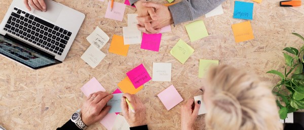 Händer som jobbar med postit-lappar