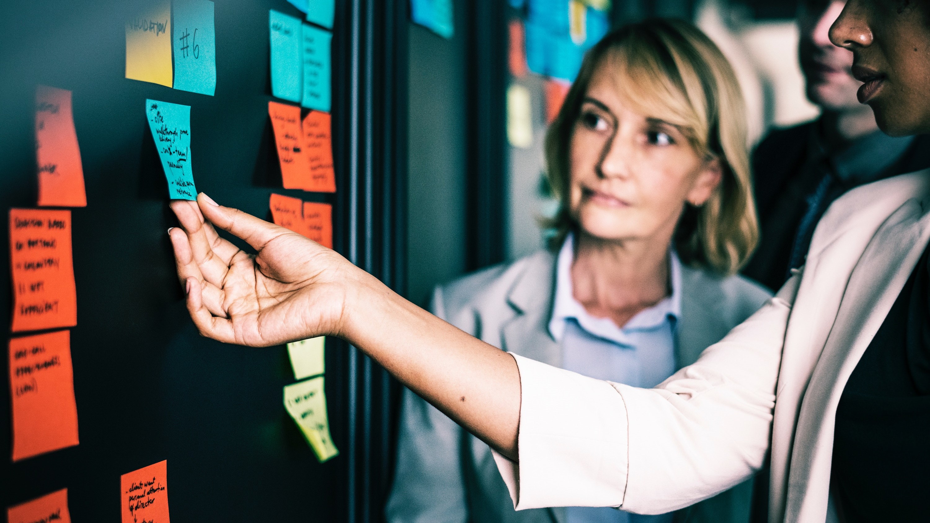 tre personen diskuterar utifrån post-it-lappar.